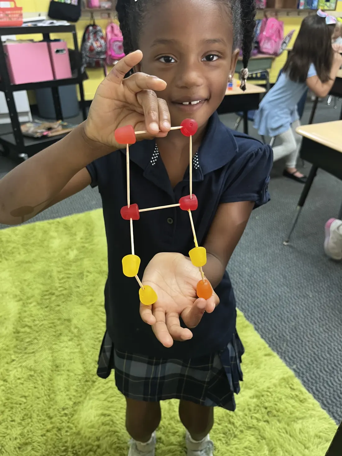Student displays a toothpick-and-gumdrop structure