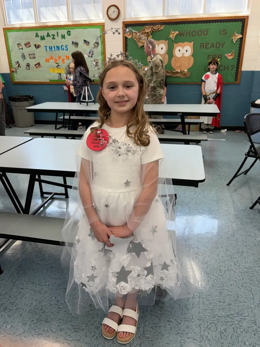 Student dressed as a galaxy of stars in a white costume covered with silver stars