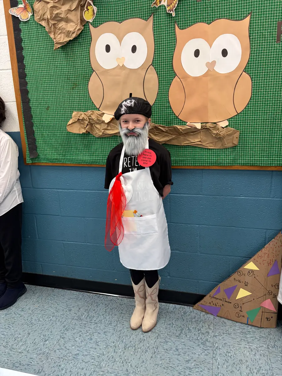 Student dressed as a French artist with a beret, beard, palette, and brushes
